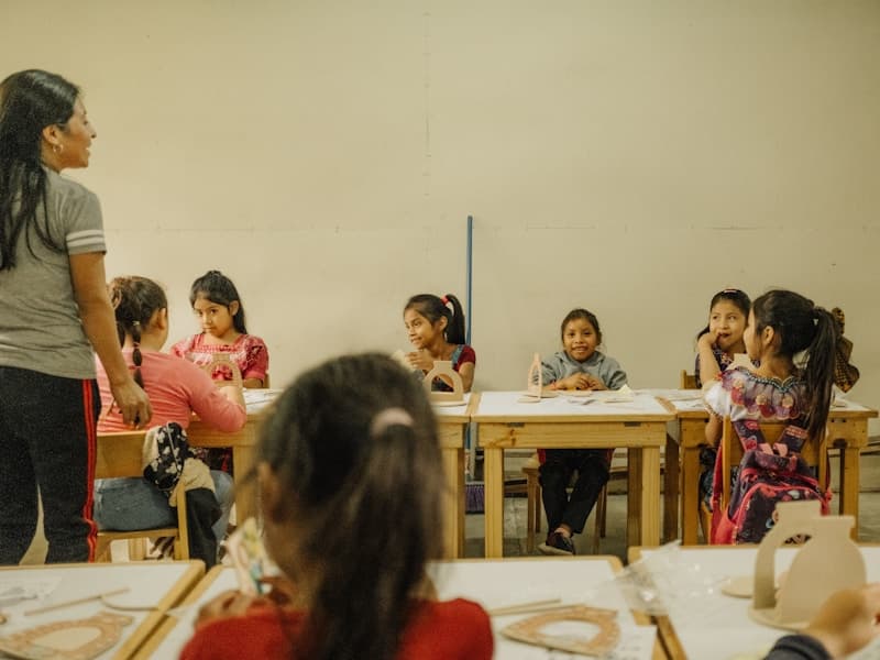 Diverse group of children sitting at desks in a classroom, engaged in learning